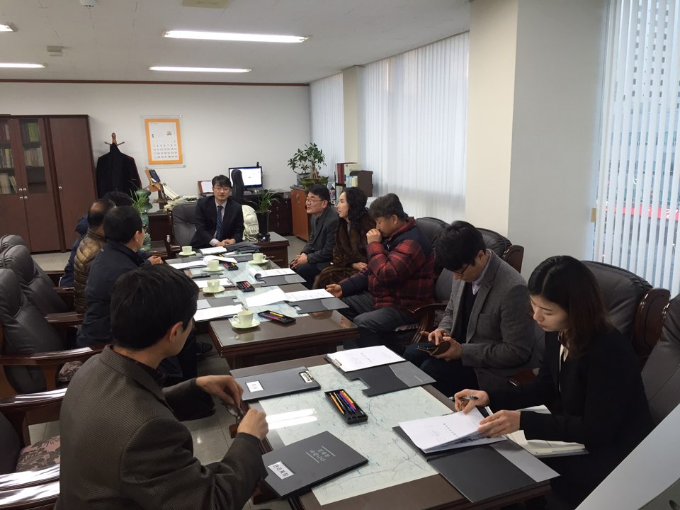 위원회 위원장, 위원 및 사무국장이 위원회의실에 의자에 둘러 앉아 위원회의를 하고 있는 모습