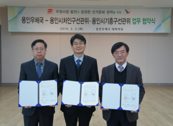 용인시처인구·기흥구 사무국장 및 용인우체국장이 업무협약서 서명 후 협약서를 들고 기념촬영을 하고 있는 모습의 사진입니다.