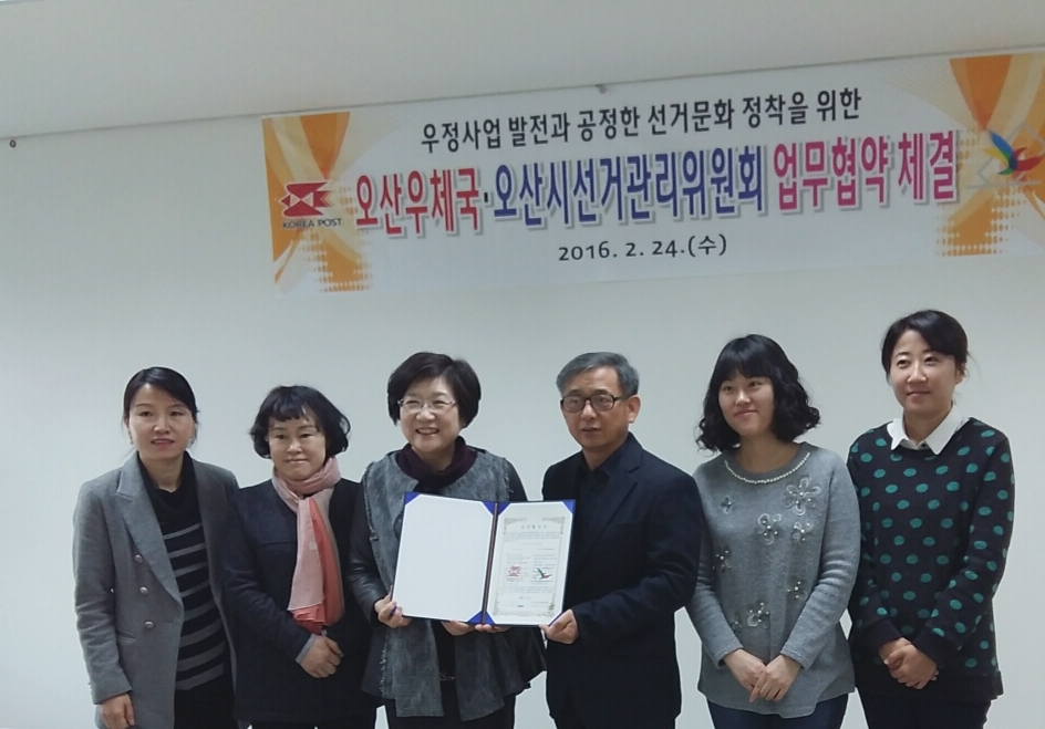 오산시선거관리위원회와 오산우체국이 공정한 선거문화 정착을 위한 업무협약을 체결하고 기념촬영을 하고 있는 모습의 사진입니다