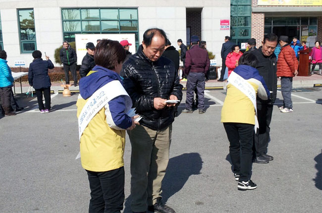 동두천시 상패동주민센터 앞 마당에서 공정선거지원단 단원들이 제20대 국회의원선거 투표참여 홍보리플릿을 배부하고 있는 장면